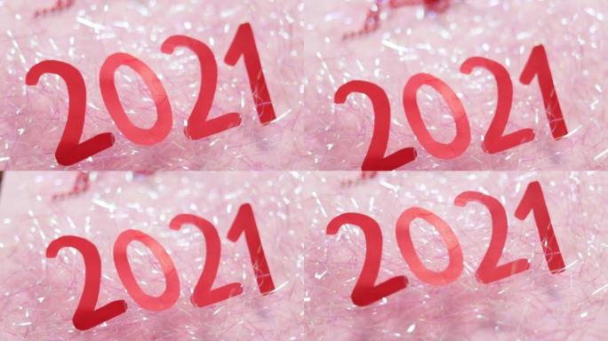 金属丝上的铭文2021。数字从粉红色背景的红纸2021。新年概念视频。特写
