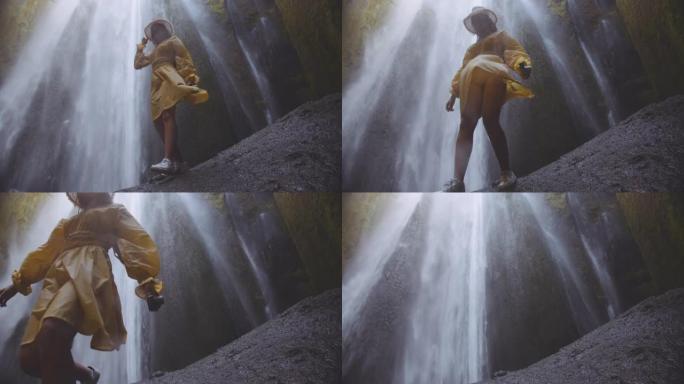 瀑布底部黄色的年轻女子