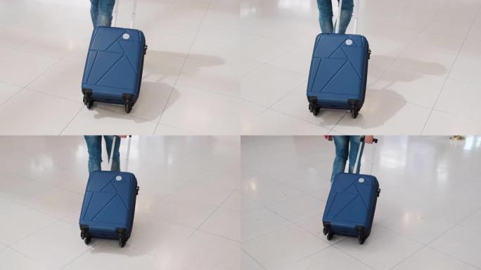 低角度女人在机场出发时带着手提箱行走