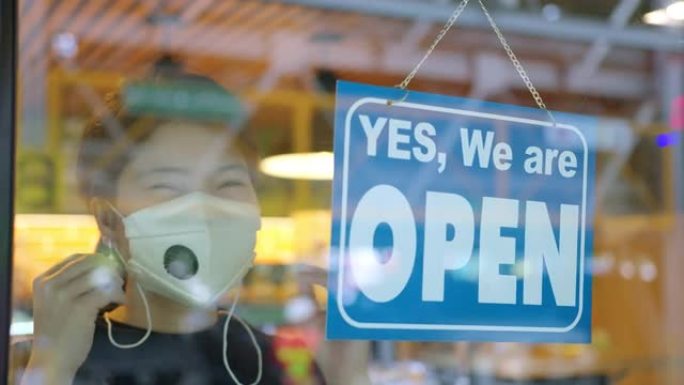 亚洲女性手放开放标志店从新型冠状病毒肺炎传播和锁定第二是政府健康和检疫概念的公告