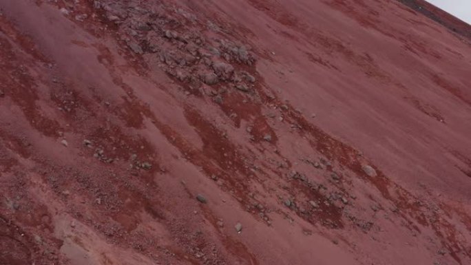 鸟瞰图慢慢飞过vulcano山丘上的红色硫化沙和大岩石