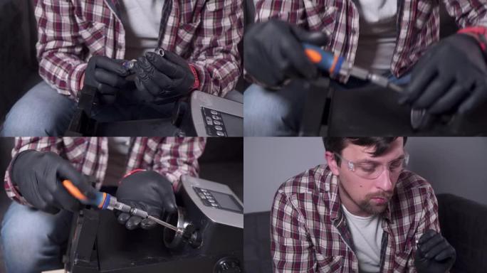 一个年轻人正试图在家里修理自己的厨房电器，咖啡机。高加索男性用穿着格子衬衫、安全眼镜和手套的螺丝刀修