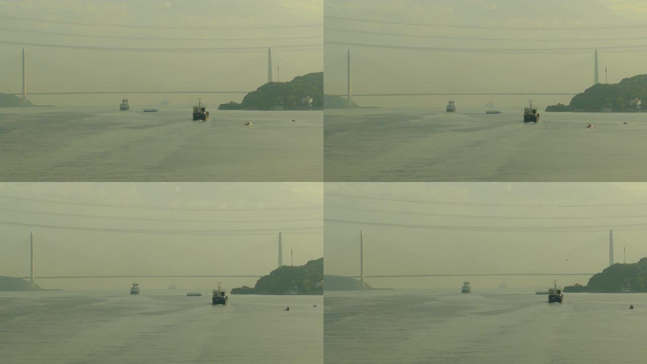 黎明时的货船在博斯普鲁斯海峡的桥下通过