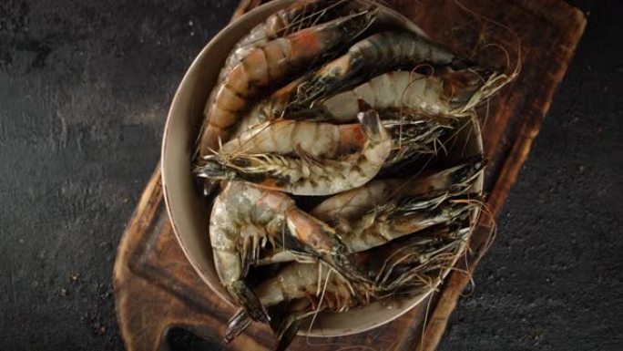 切菜板上的碗中的生虾旋转。