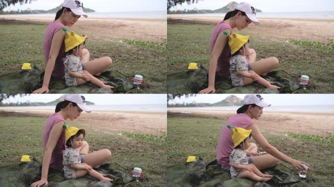 年轻的母亲在海边和她的小女孩玩耍。
