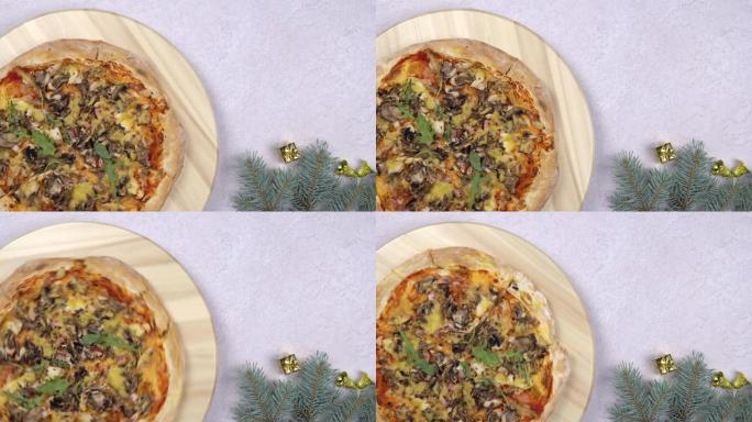平放的比萨饼旋转360度旋转在木制的salver，圣诞装饰品周围。