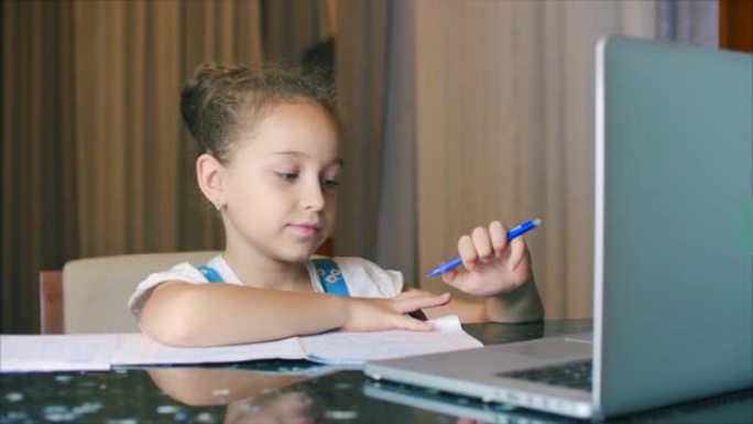 小女孩一个可爱的7-8岁的小学生在家学习家庭学习听学校讲座不离家做作业。孩子在家上学，孩子教育理念