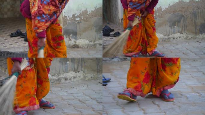 印度斋浦尔2021年1月-马赫罗利。用扫帚扫地水泥块。在家打扫工作的女人。