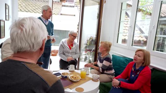养老金的老年人聚集在茶话会上，度过了一段美好的时光
