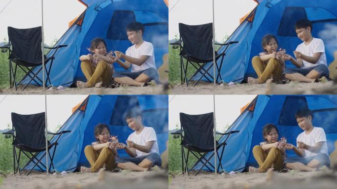 亚洲男孩和女孩在度假时与家人露营时玩烟花