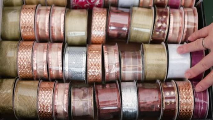 手触摸许多丝带，象征着在工艺品店选择的困难。