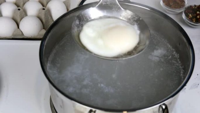 煮荷包蛋的食谱。煮鸡蛋从锅里的沸水中取出。