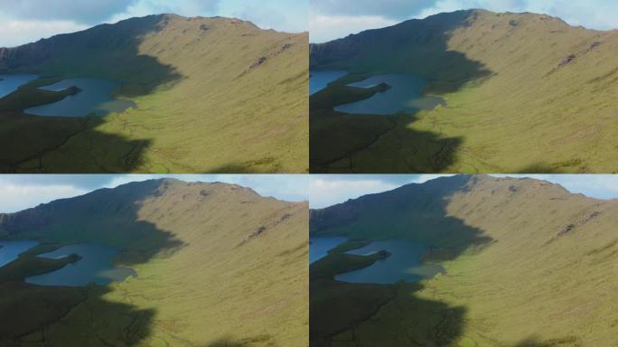 科尔沃火山绿色斜坡上的阳光和阴影。亚速尔群岛卡尔迪拉奥火山口的航拍