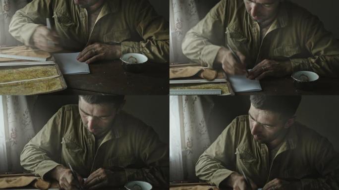 苏军士兵坐在窗边的废弃房子里，分析地图并制定行动计划