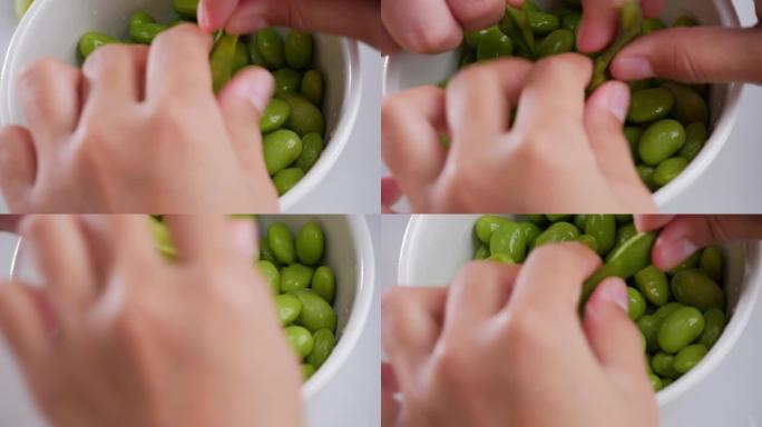 在白碗里吃绿色大豆。