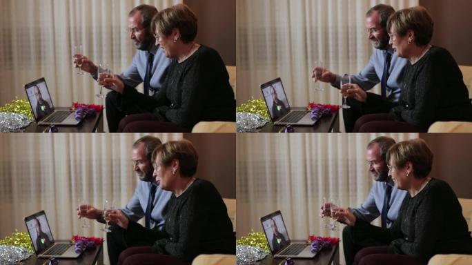 高级夫妇在家里的笔记本电脑上通过视频通话向儿子致意。圣诞节和新年概念中的社交距离