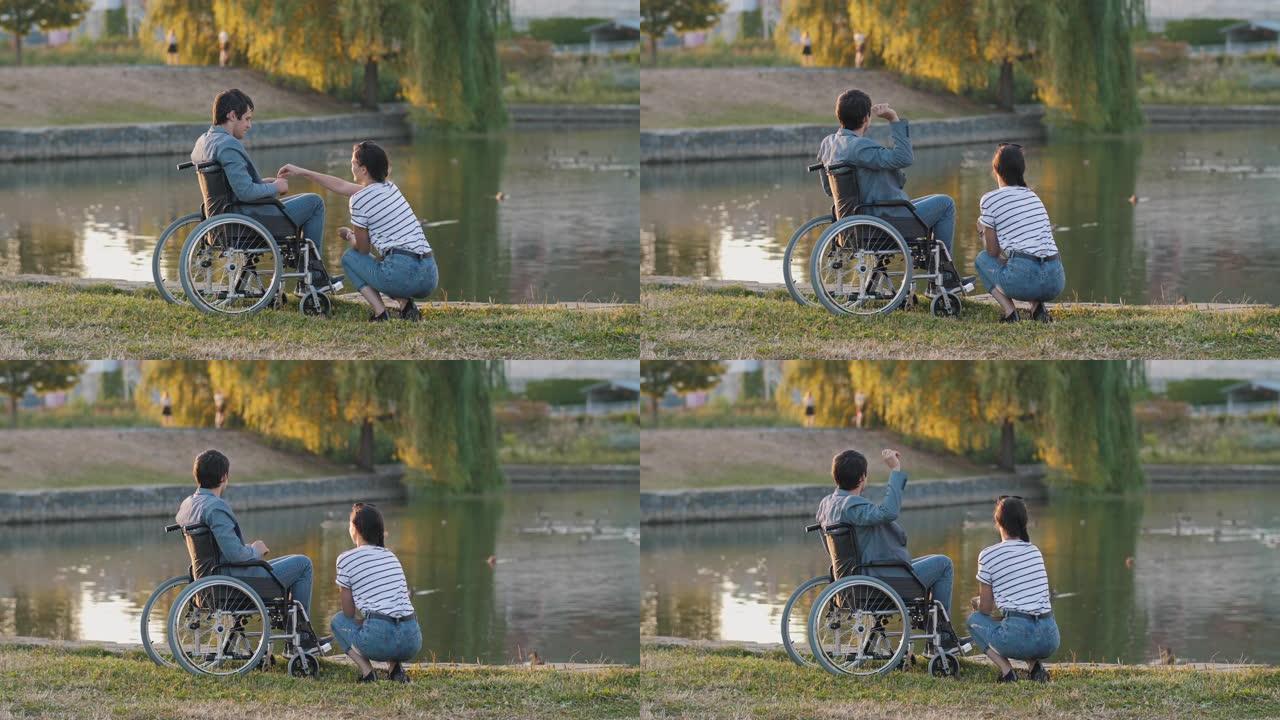 女人和男人坐在轮椅上喂鸭子
