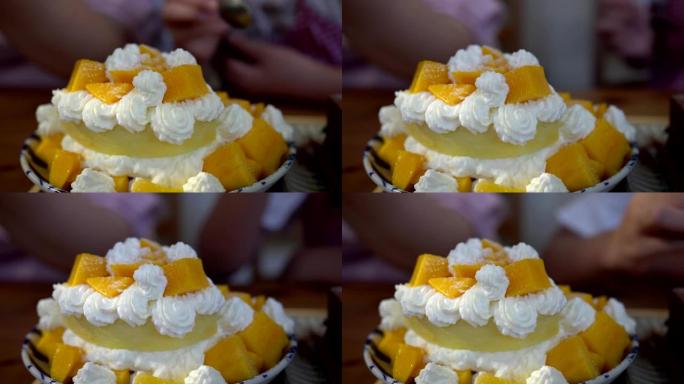小女孩在餐馆吃甜点。盘子里芒果蛋糕的特写。