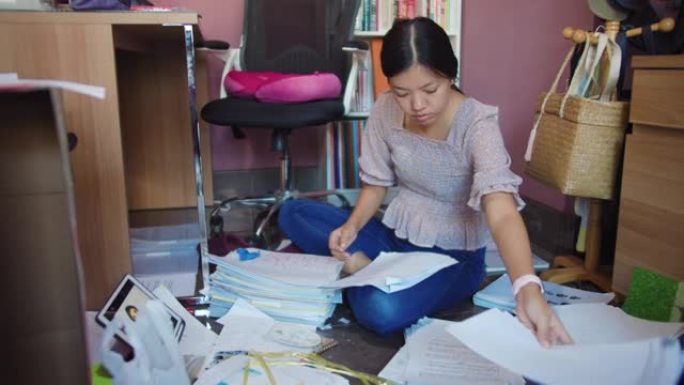 亚洲女性在新年前夕将文件存储在家庭办公室，以便在整洁的工作场所中更好地工作。新家庭办公室setup.