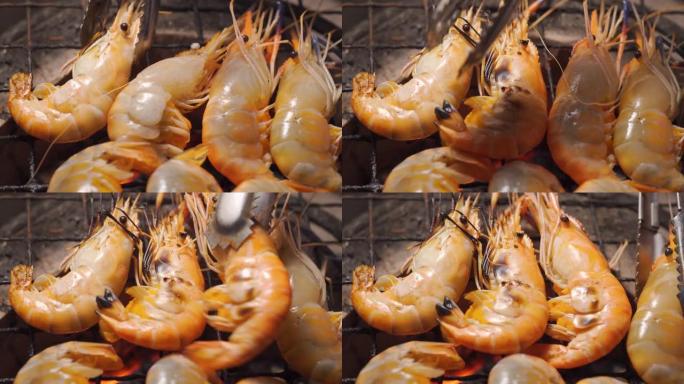 在充满火和火焰的传统炉子上烤虾。泰国和夏季的海鲜菜单。市场，街头食品。美味可口的菜单。宏观拍摄。