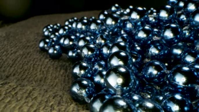 地毯上的蓝色珠子花环特写。库存镜头。装饰背景与闪亮的珠子花环，概念的圣诞节和新年寒假