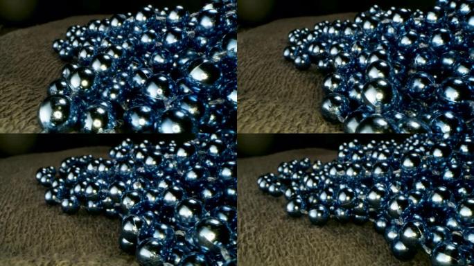 地毯上的蓝色珠子花环特写。库存镜头。装饰背景与闪亮的珠子花环，概念的圣诞节和新年寒假