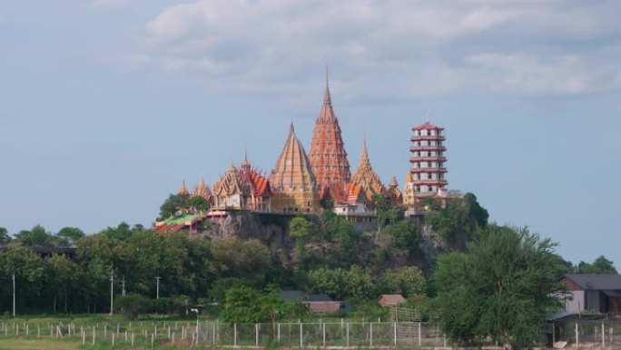 时光流逝的Wat tham sua或tiger cave temple，带有绿色的茉莉稻田，蓝天，阳