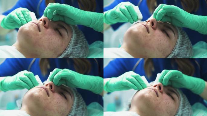 细心的美容师在诊所中挤压女人脸上的丘疹