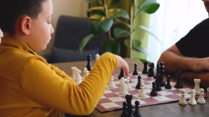 父子俩一起在家下棋。家里的家人。