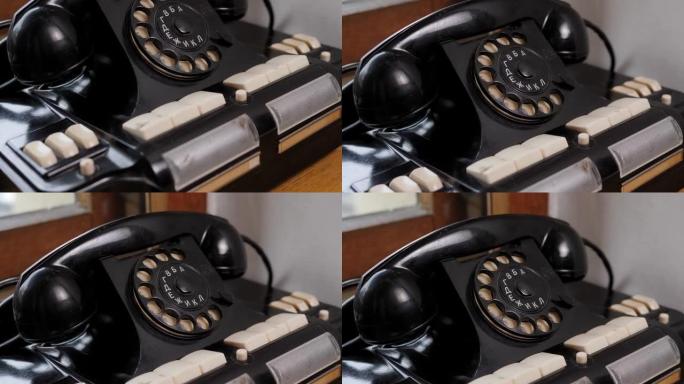 老式黑色手机在旧木桌背景。