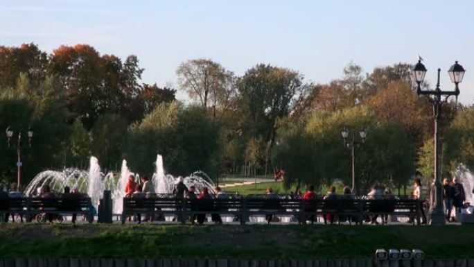 莫斯科夏天，人们在喷泉附近的长凳上公园。