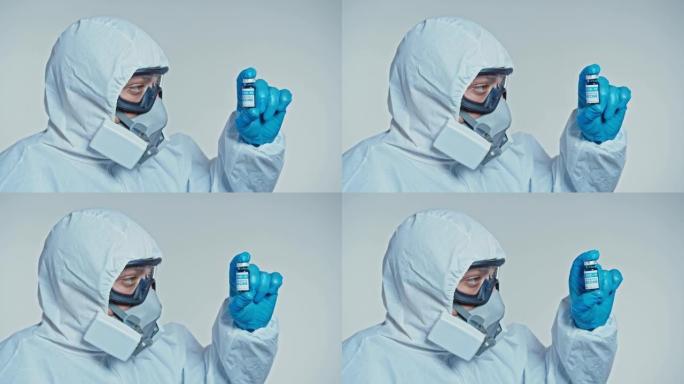 特写一位开发了冠状病毒疫苗的蒙面科学家拿着一瓶蓝色液体，并检查了疫苗。医生在用药前先看一下药