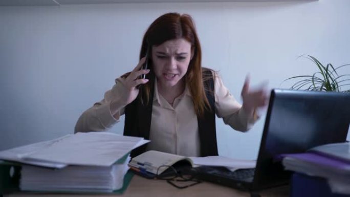 愤怒的女上班族带着精神障碍在电话上交谈时因愤怒而尖叫，并因工作中的神经衰弱而扔纸，压力管理