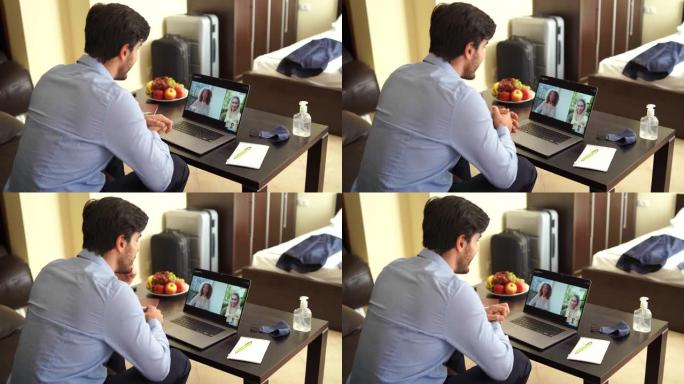 新型冠状病毒肺炎期间，酒店房间里的4k视频商人使用笔记本电脑进行视频会议
