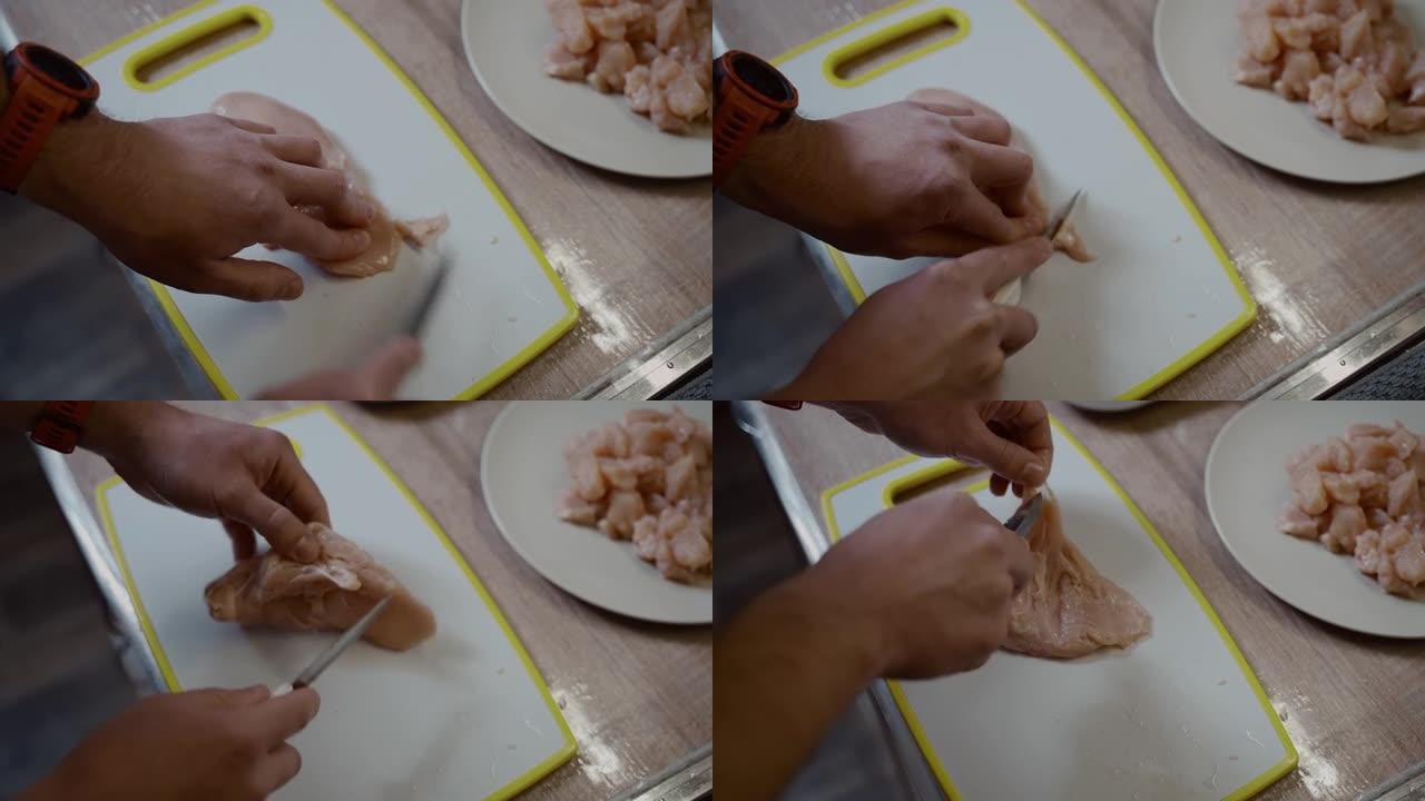 高加索年轻男性的特写手正在厨房里的塑料白板上切新鲜的鸡肉。爱好烹饪，单身汉做晚餐。一个孤独的人准备家