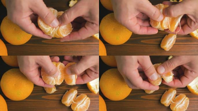 男性手剥橙色柑橘类水果在木制背景，顶视图
