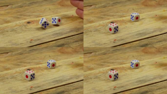 手在木桌上扔了两个骰子。特写