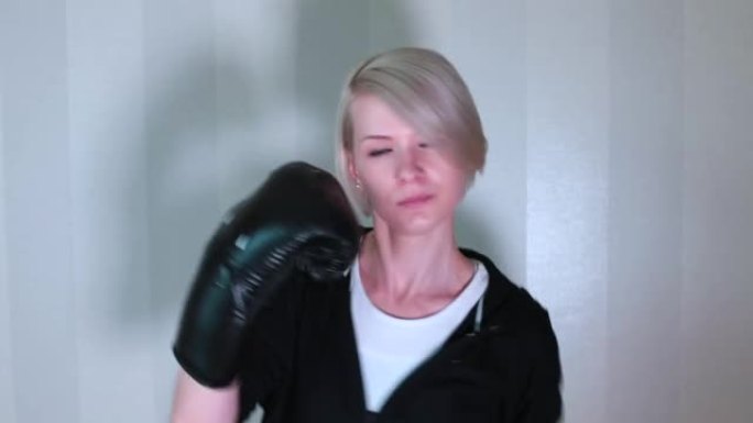 用手拳击。女人用拳击手套在家锻炼的肖像。