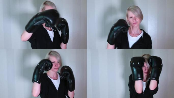 用手拳击。女人用拳击手套在家锻炼的肖像。