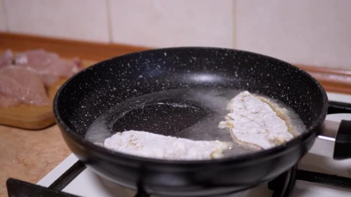 雌性手将鸡排放在热煎锅上。煮肉
