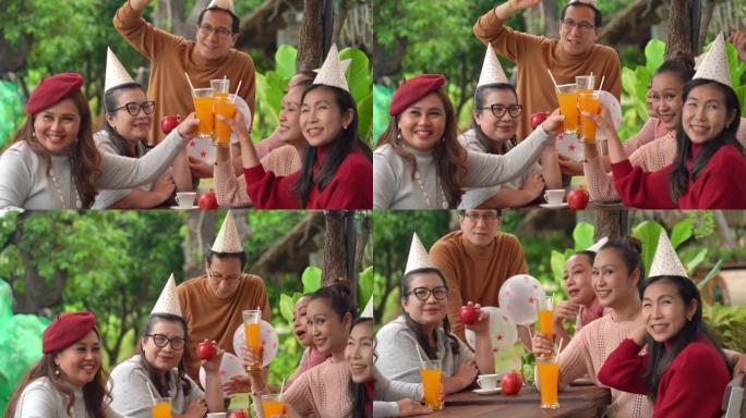 公园里的家庭聚会，喝有机橙汁，并使用网络摄像头与其他人一起欢呼