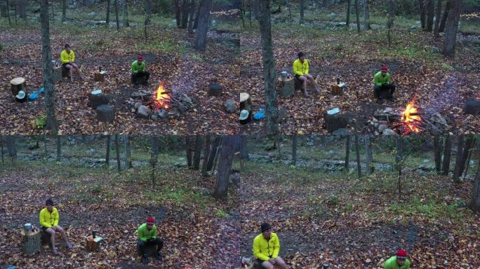 两个人坐在篝火旁-森林-秋天