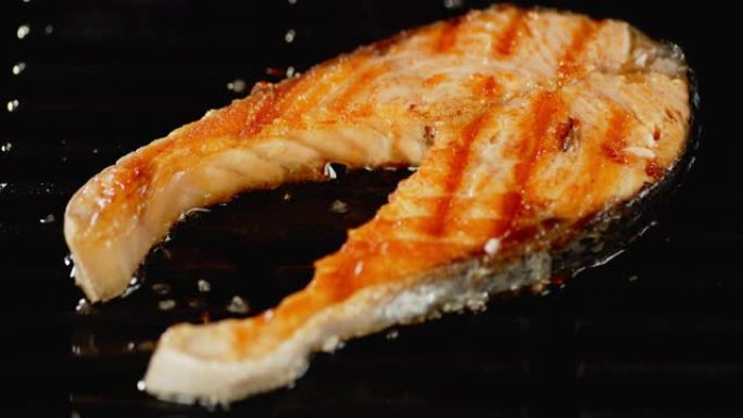 新鲜的三文鱼排在油锅中油炸。