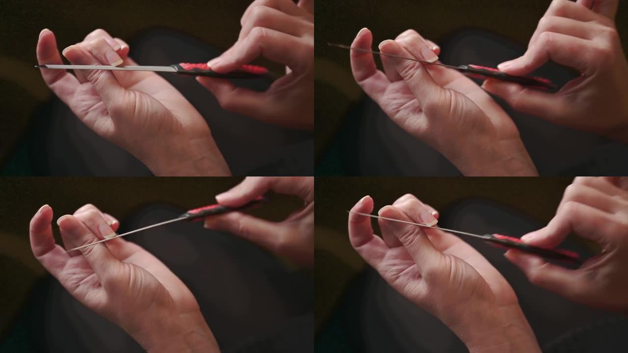 指甲处理。一个女人在家做修指甲，用指甲锉磨指甲，用手特写。
