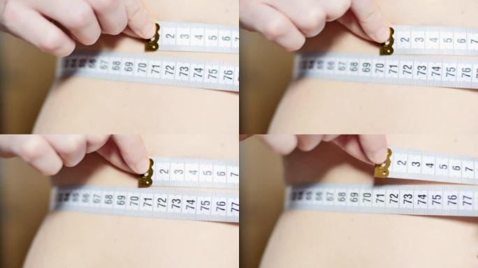 女人用卷尺测量她的腰。
