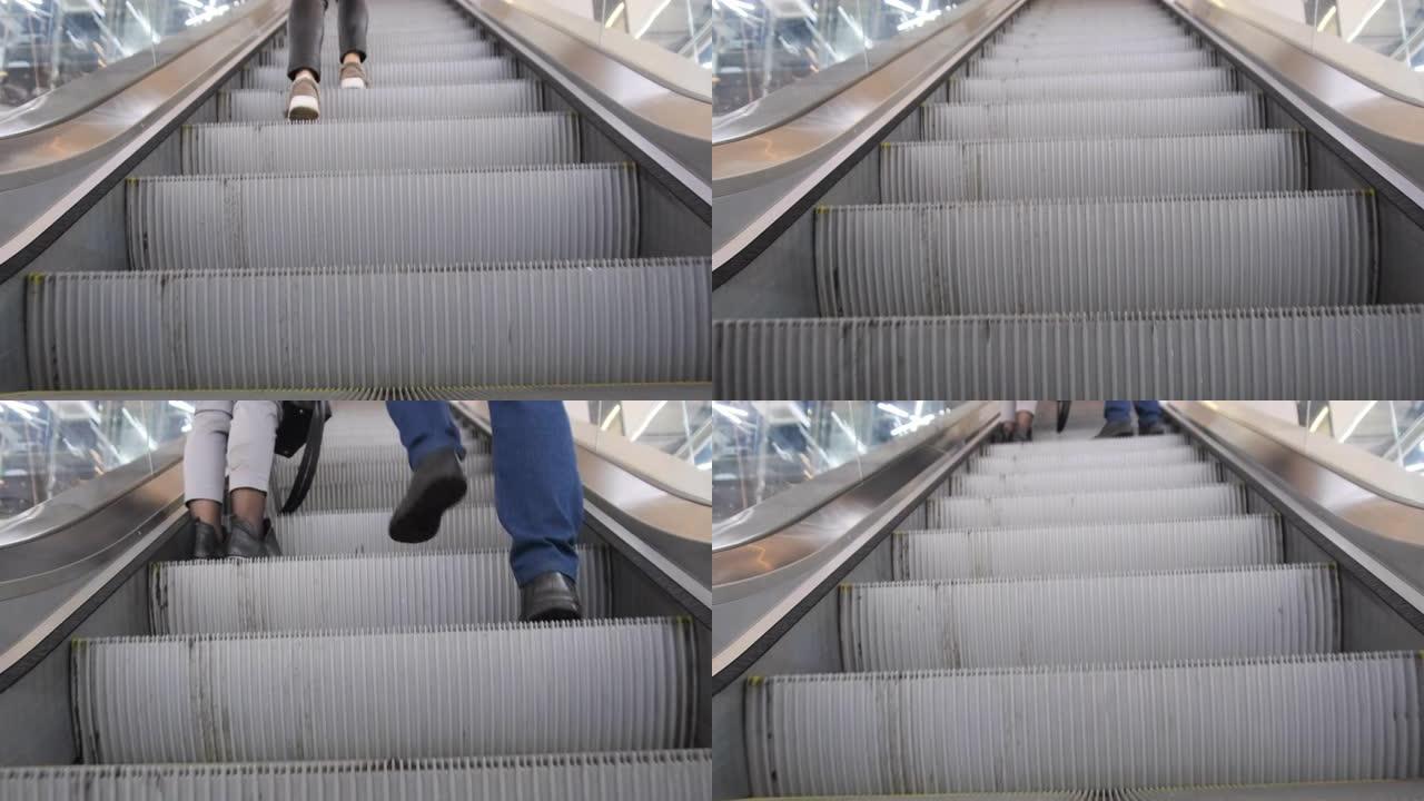 人们的脚在购物中心的空自动扶梯上。底视图