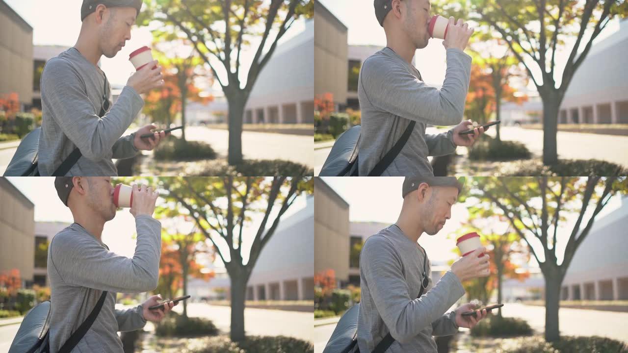 一名日本男子一边用可重复使用的咖啡杯喝咖啡，一边使用智能手机