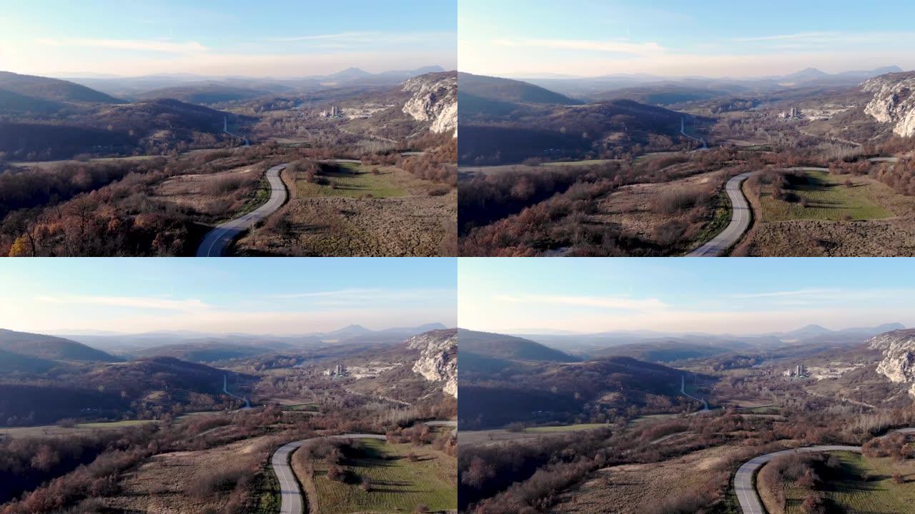 从山上飞来的无人机的航拍-越过山的道路，山的岩石景观