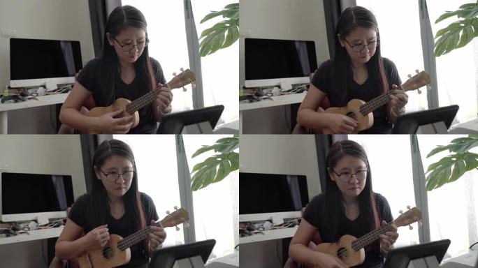 亚洲女性在家自学网络学习演奏夏威夷四弦琴。