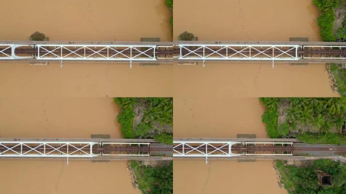空中慢镜头拍摄了一条河上的金属铁路桥，该桥具有棕黄色